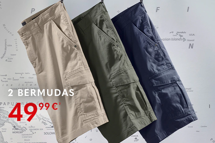 Mehrere einfarbige kurze Chinos in verschiedenen Farben hängen nebeneinander auf Kleiderbügeln an einer Metallstange. Im Hintergrund ist eine Weltkarte zu sehen.