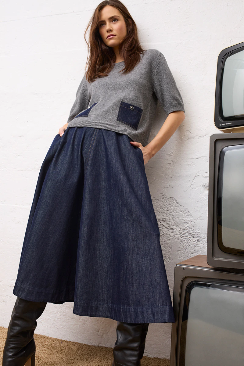 A grey women’s knitted jumper with denim details, paired with a dark blue denim skirt from Oui.