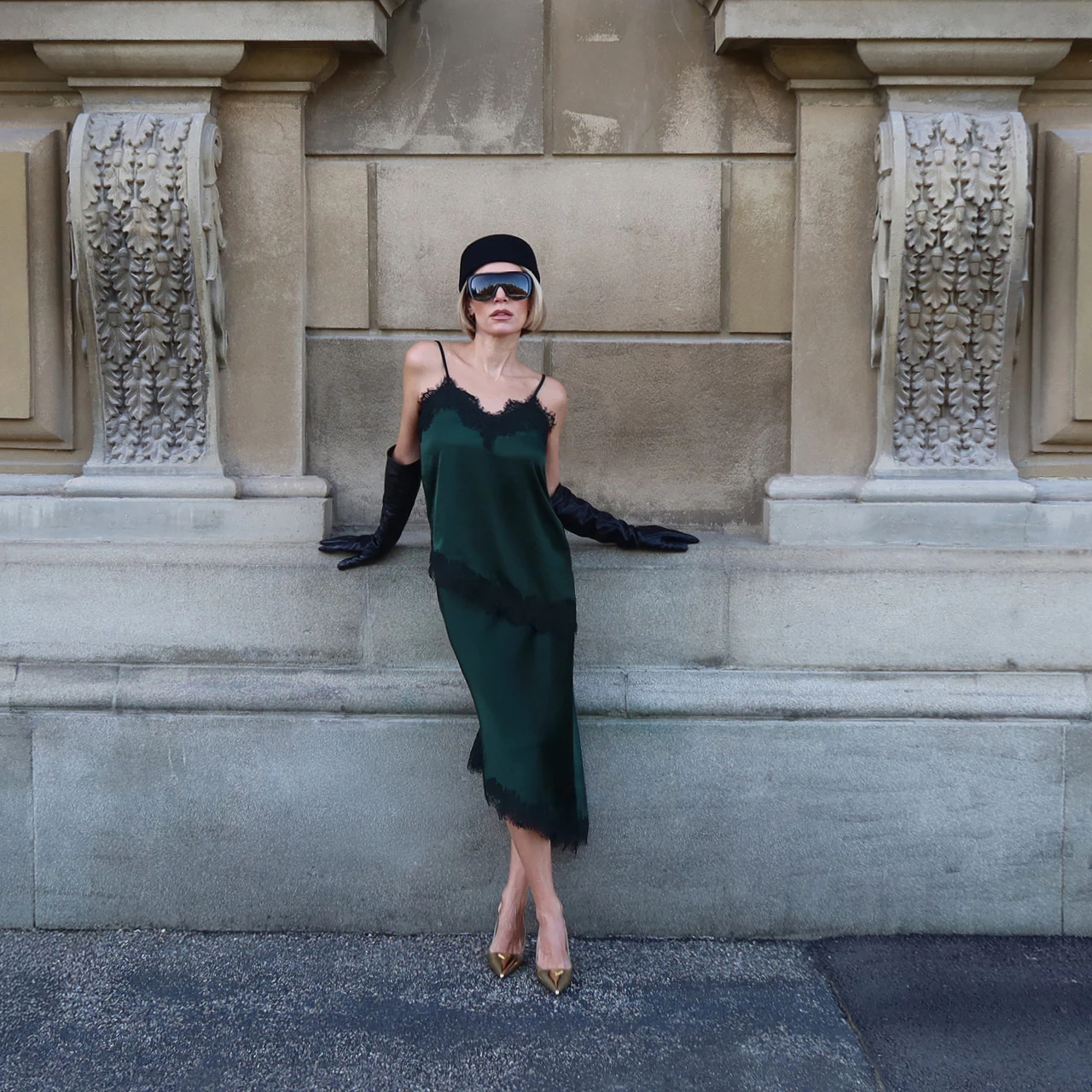 Influencer Sophia Thorer is wearing a head-to-toe dark green outfit consisting of a lace top and a skirt with a lace hem.