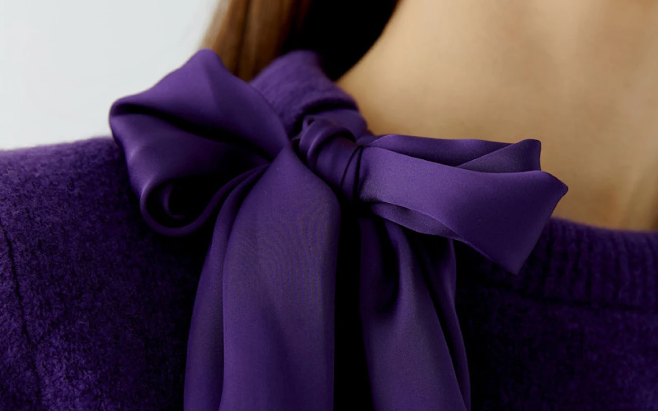 Image showing the trend colour purple, featuring a purple bow-neck blouse.