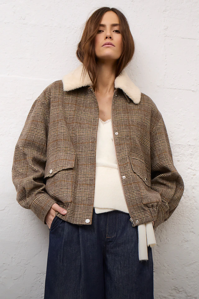 Damenmode von Oui mit karierter Jacke, darunter weißer Wickelpullover und Hose.