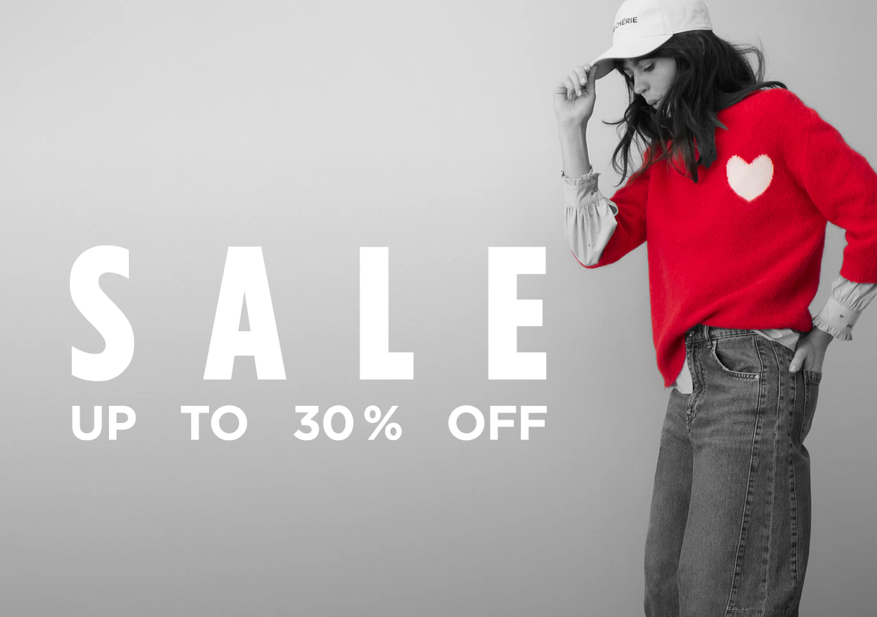 The image, in black, white and grey, shows a woman wearing a red jumper with a white heart and the words: SALE up to 30%