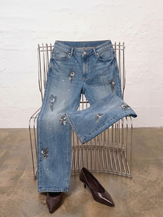 A pair of jeans thrown over a metal chair.