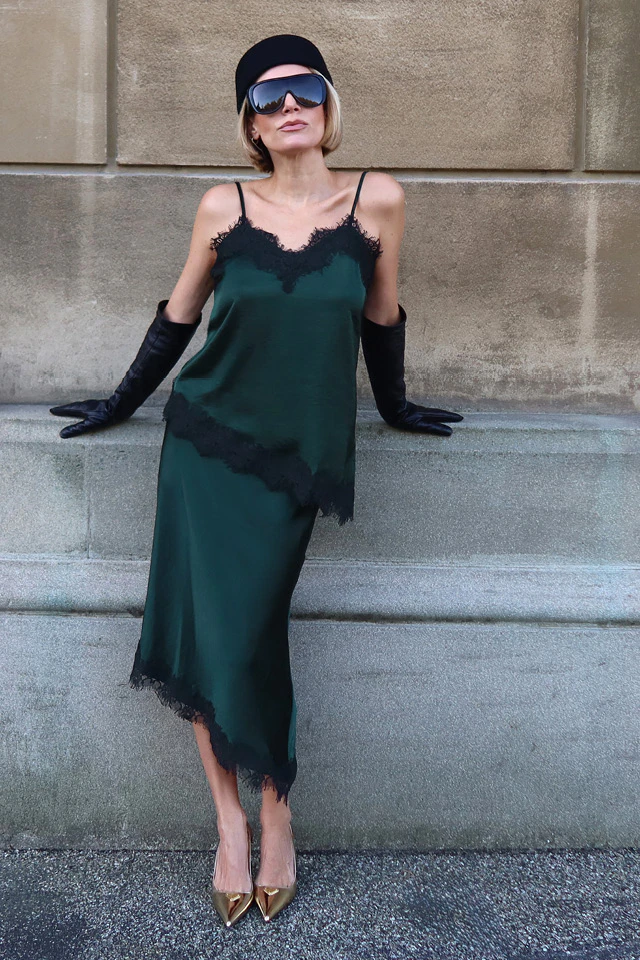 Influencerin Sophia Thorer trägt einen total Look in dunkelgrün bestehend aus Spitzentop und Rock mit Spitzensaum.