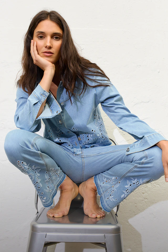 Frau trägt einen Jeanslook bestehend aus einem Jeanshemd und einer Jeanshose.