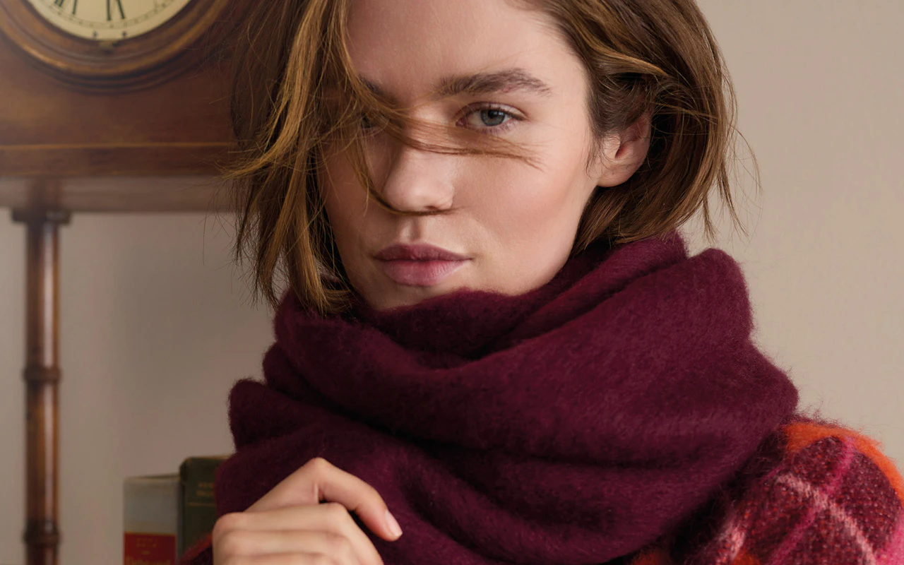 Model trägt kuscheligen Strickschal in bordeauxrot.
