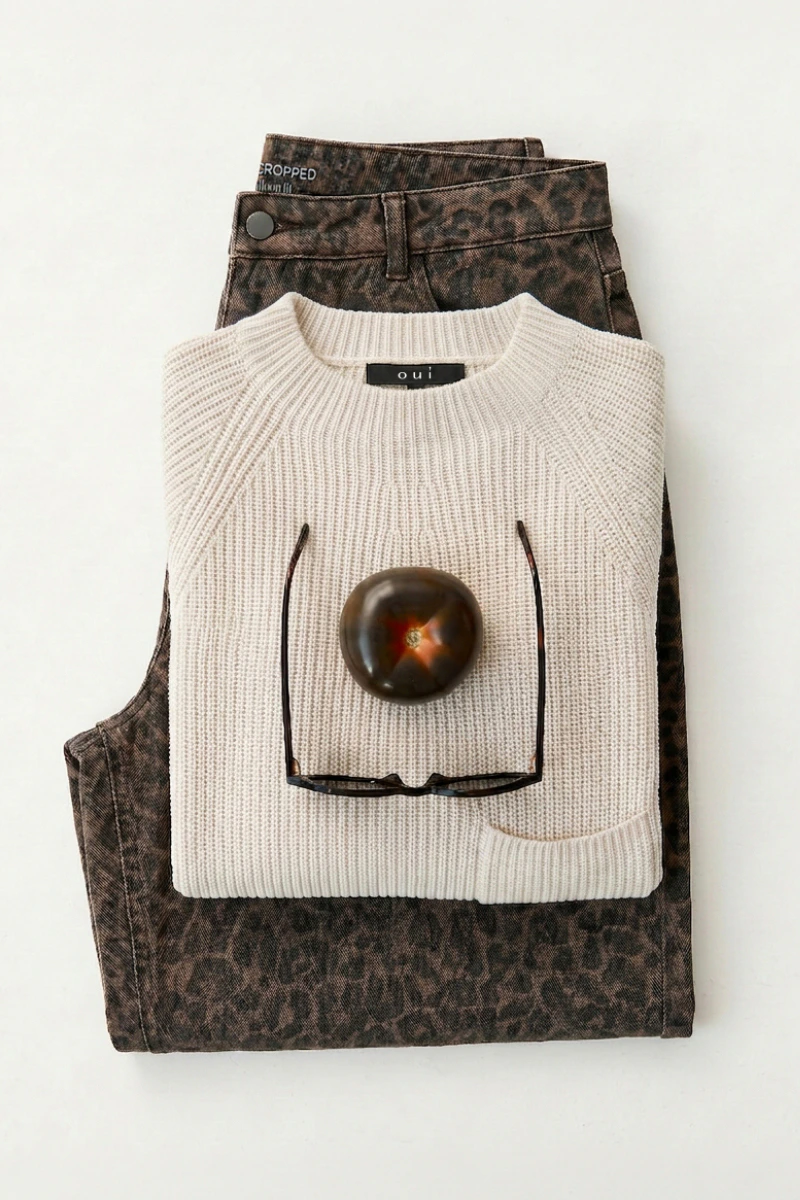 Damenmode von Oui mit Strickpullover und gemusterter Jeans als Outfit-Kombination.