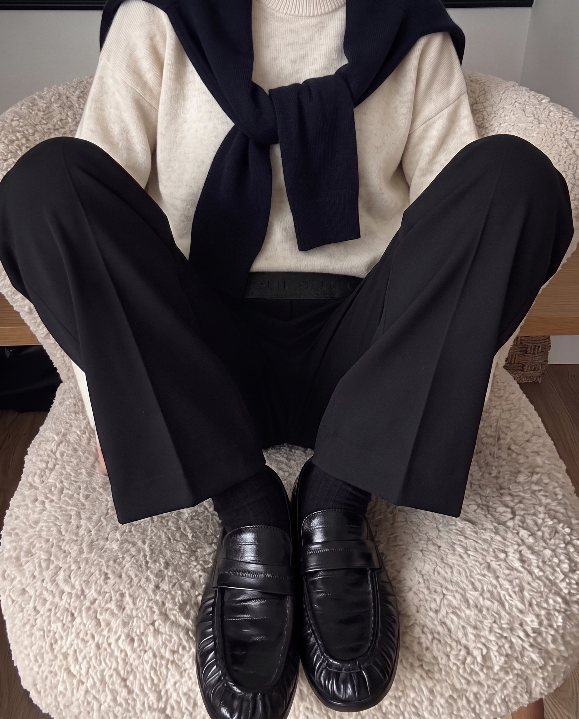 Oui Essentials: Cremefarbener Pullover mit schwarzer Hose, Schal und schwarzen Loafern im entspannten Look.