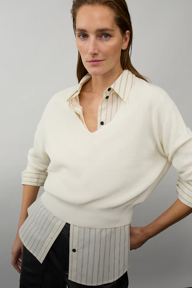 Women’s fashion from Oui, featuring a striped white blouse with a cream-coloured jumper worn over it.