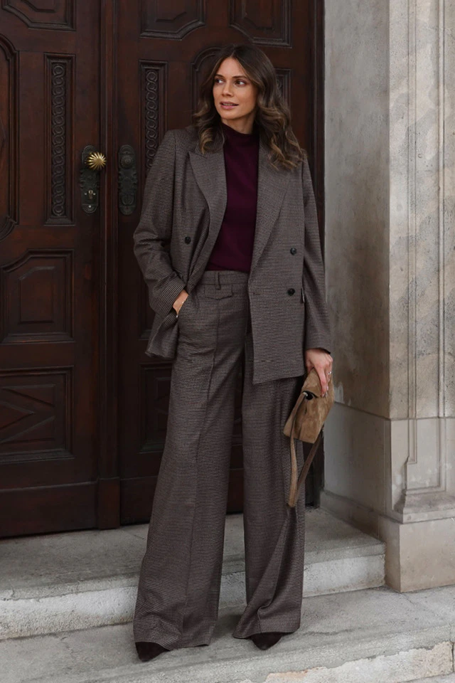Influencer Raffaela Wachter in an Oui look, wearing a burgundy jumper and a checked trouser suit comprising a blazer and wide-leg trousers.