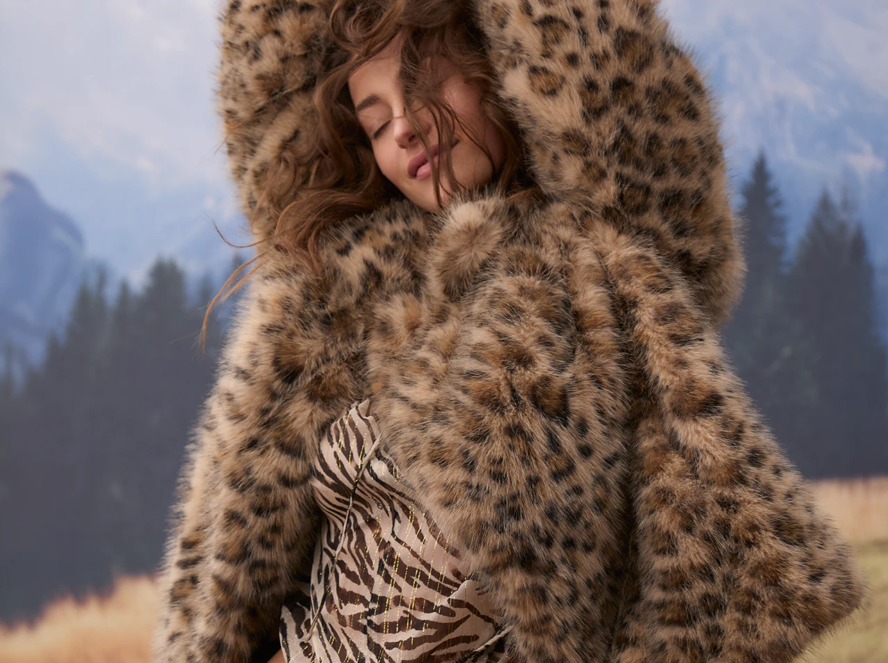The model is wearing a striking leopard-print jacket over a zebra-print top.