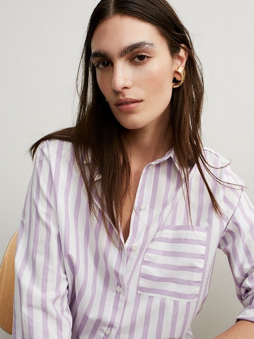 Frau mit Bluse in weiß und lila gestreift.