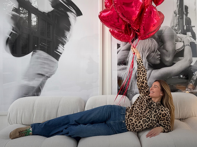 Lena wears our leo blouse with a simple denim. She's also holding several red heart balloons.
