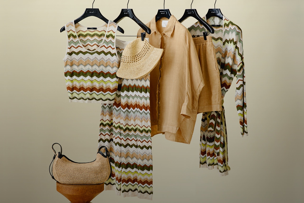 Stange mit Top, Rock und Strickjacke mit zickzack Muster in den Farben braun, weiss, gruen, beige und eine Bluse und Short in braun.