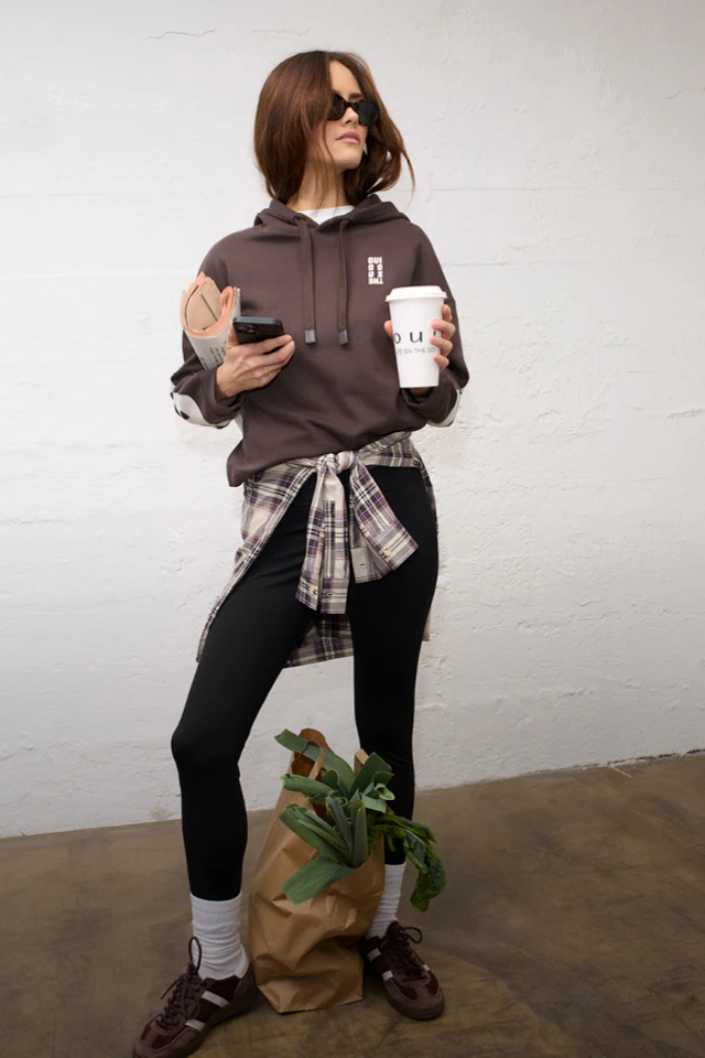 Women’s fashion from Oui, featuring a brown hoodie, a checked blouse and black trousers from the current collection