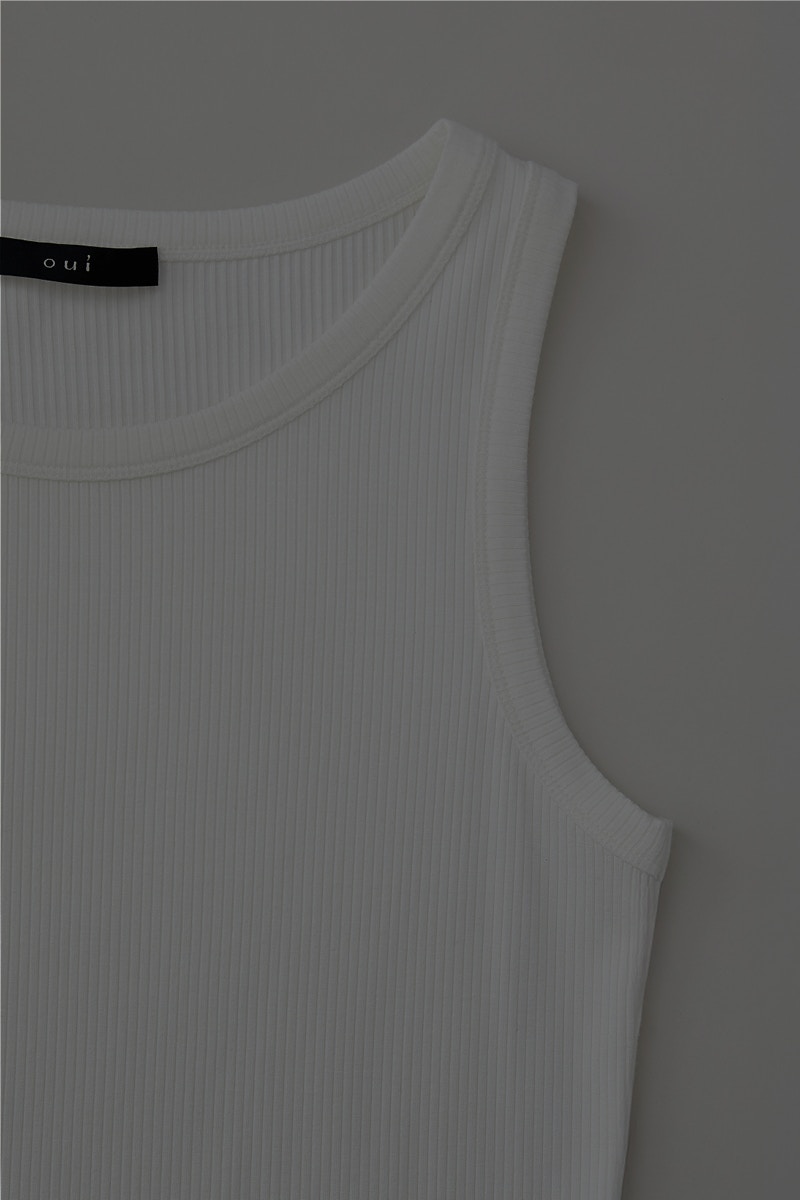 A close-up of a top with half a side of the armhole and neck collar.