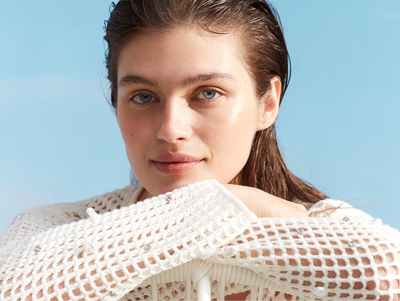 Woman with an airy knitted jumper with glitter details.