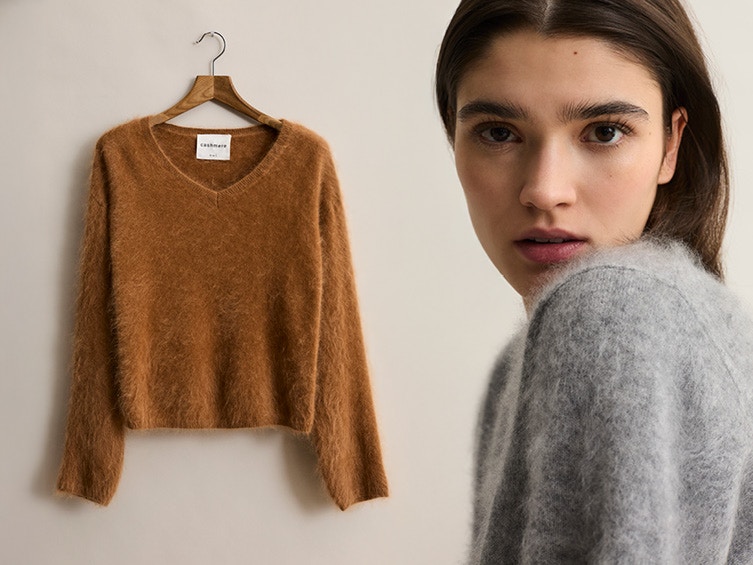 Frau mit graunem Pullover und ein brauner Pullover auf einem Kleiderbügel.