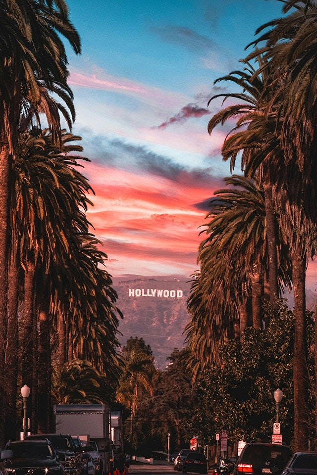 Ein Bild von LA und dem Hollywood Schriftzug bei Sonnenuntergang.