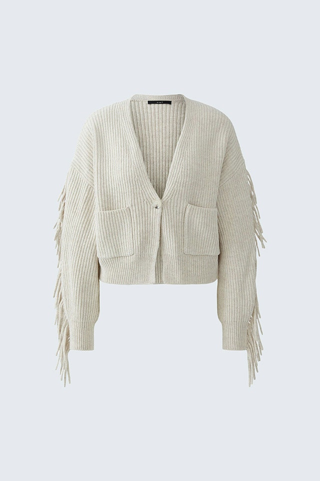A beige cardigan with fringing on the sleeves.