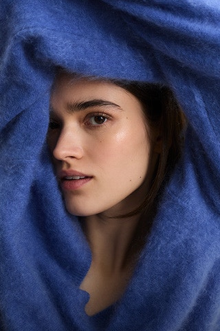 Frau mit einem blauen Pullover.