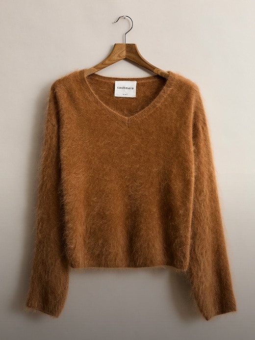 A brown plush jumper on wooden hangers photographed from the front.