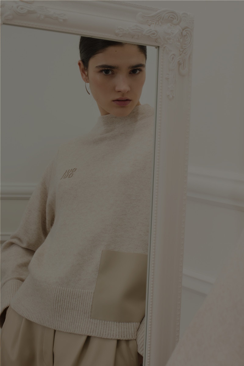 Frau mit beigem Pullover und passender Hose.