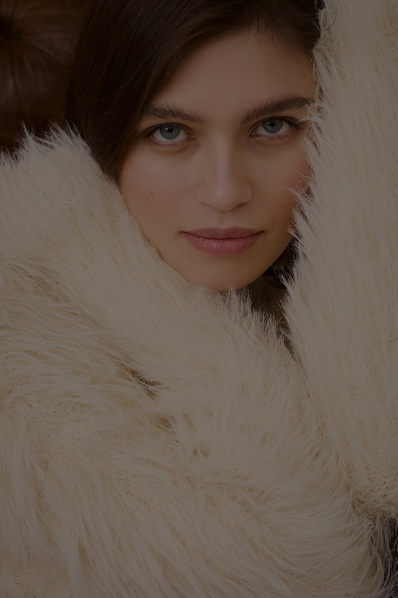 Nahaufnahme auf eine Frau die einen flauschigen weissen Pullover trägt.