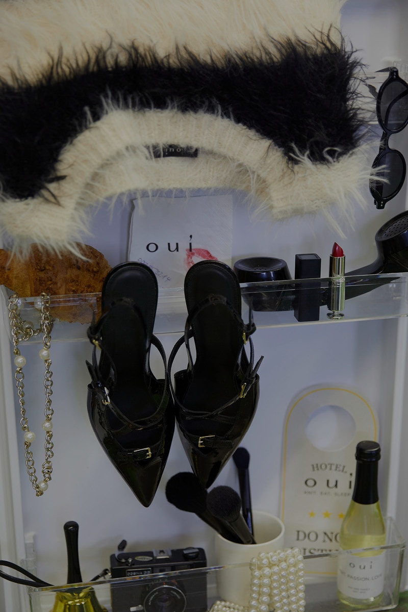 Ein Moodiges Legebild mit Kleidung, Zeitschriften, Sekt, Schuhen.