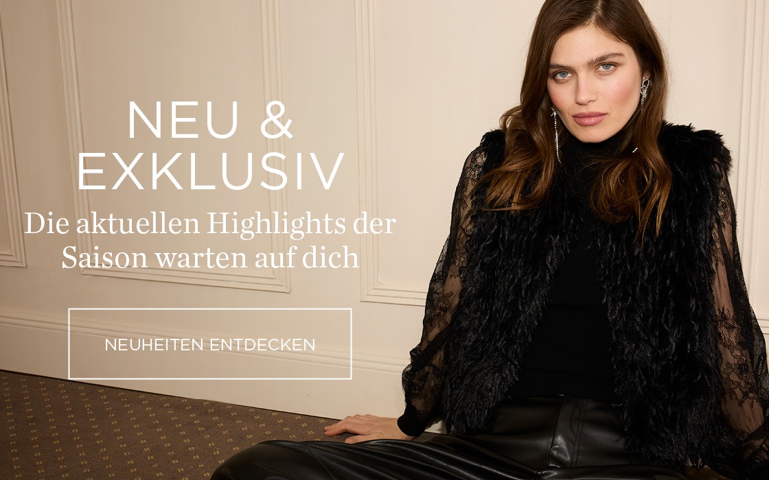 Sitzende Frau trägt einen schwarzen Pullover mit Ärmeln in Spitze, darüber eine schwarze Fransenweste und eine passende Hose in Lederoptik ebenfalls in schwarz. Schriftzug: Neu & Exklusiv - die aktuellen Highlights der Saison warten auf dich Klickfläche: Neuheiten entdecken.