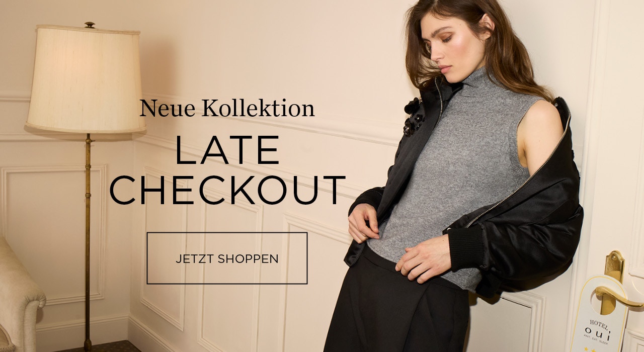 Frau trägt eine schwarze Jacke, darunter ein Rollkragen Stricktop in grau und eine passenden Hose in schwarz. Schriftzug: Neue Kollektion LATE CHECKOUT mit einer Klickfläche: jetzt shoppen.