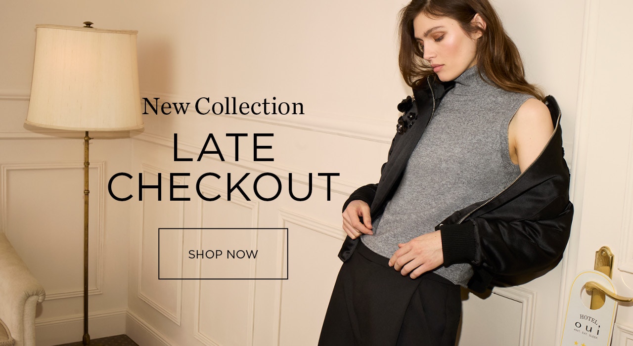 Woman wearing a black jacket with a grey turtleneck knitted top underneath and matching trousers in black. Lettering: New collection LATE CHECKOUT with a click surface: shop now.
