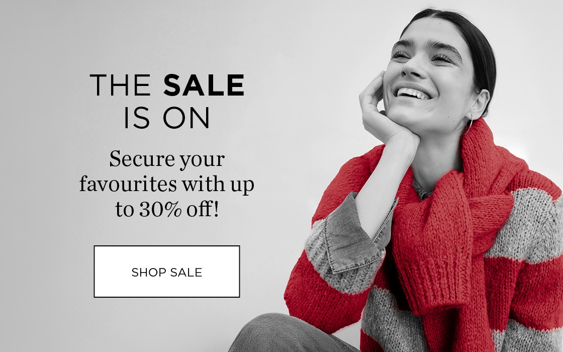 Woman wearing a red striped jumper. The sale is on.
