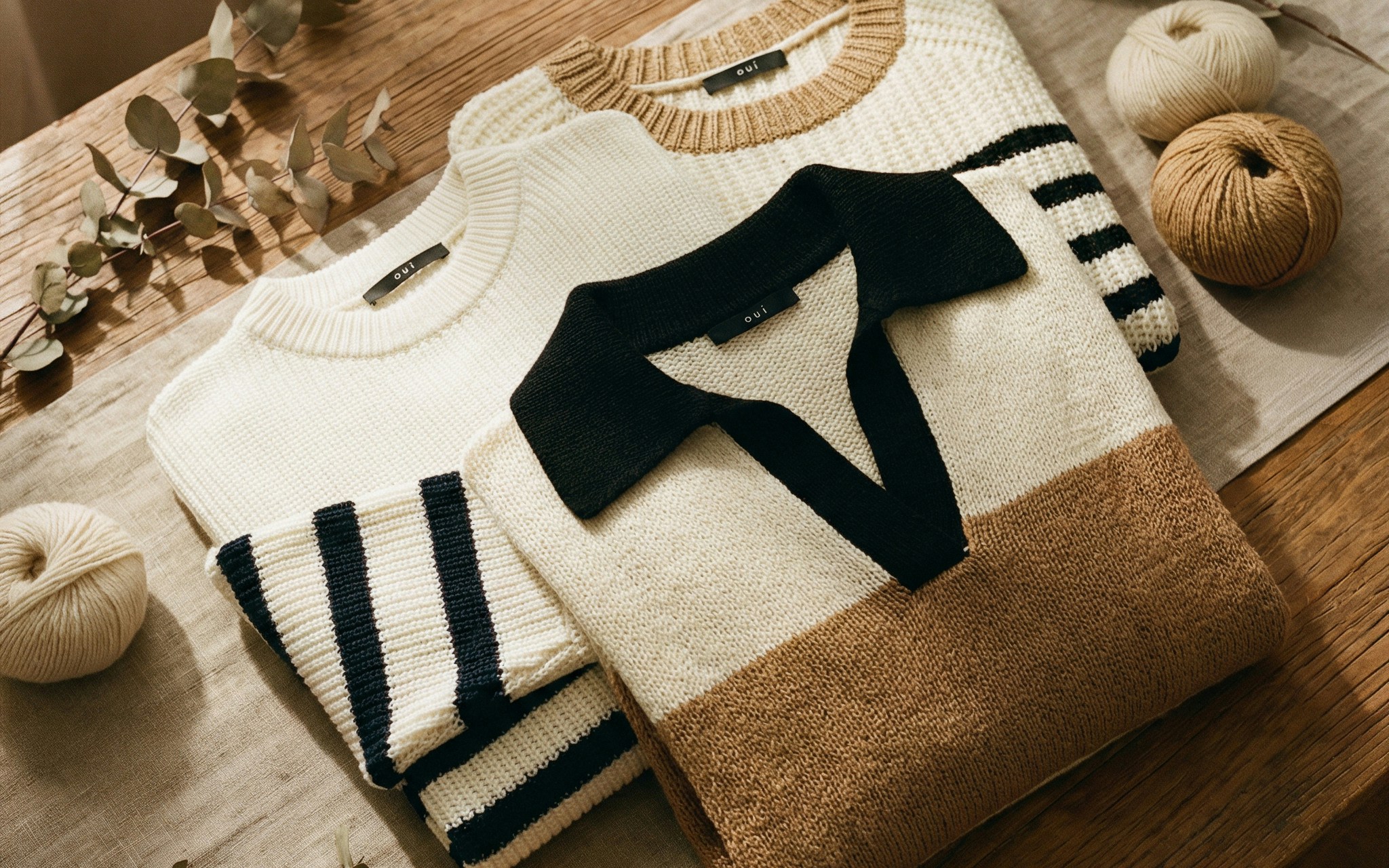 Gelegte Kleidung: 1 PUllover in schwarz weiss gestreift, einer in Blockstreifen aus braun und weiss mit schwarzem Polokragen und einer in schwarz-weiss mit braunem Kontrastkragen.