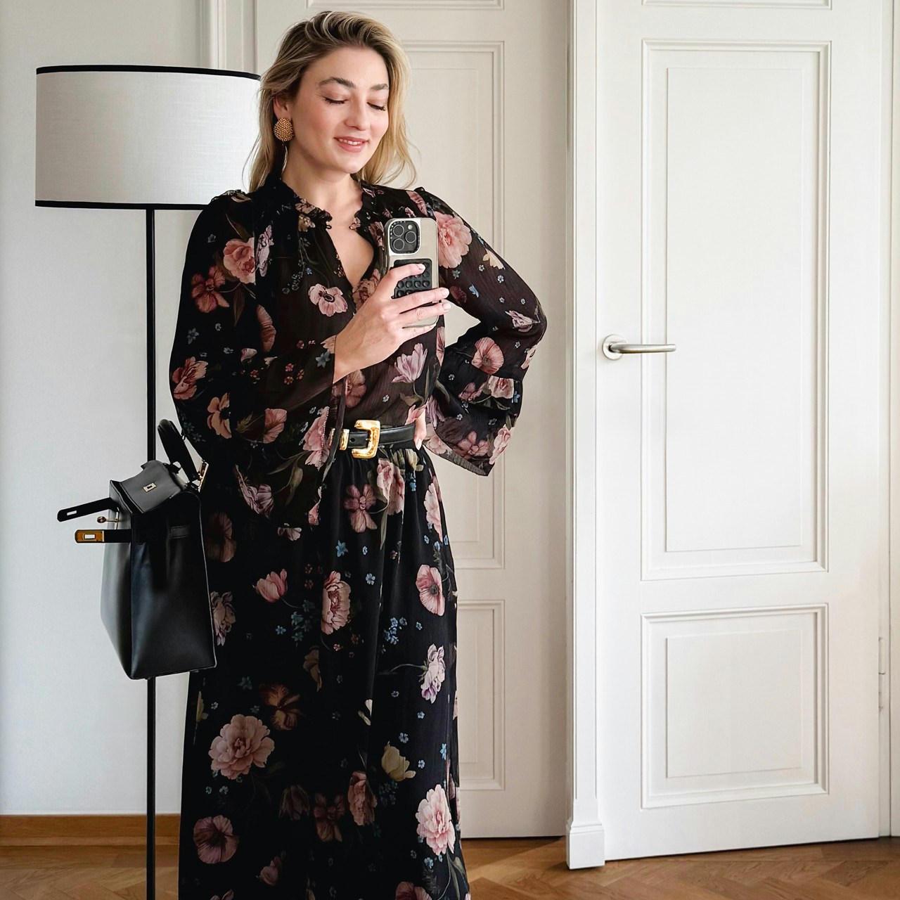 Influencer Olesya Wachter wears our black blouse with a beautiful floral print in pink, green and blue, paired with the matching skirt.