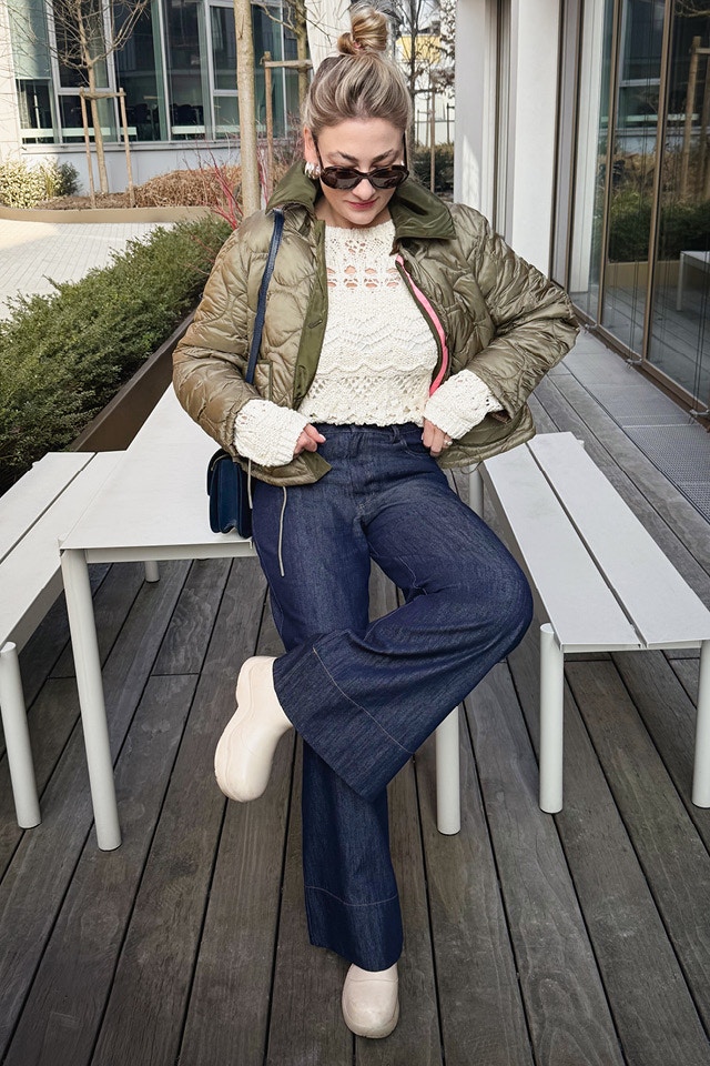 Influencer Olesya wears our reversible jacket in olive with a white crochet-look jumper and wide-leg dark blue jeans.