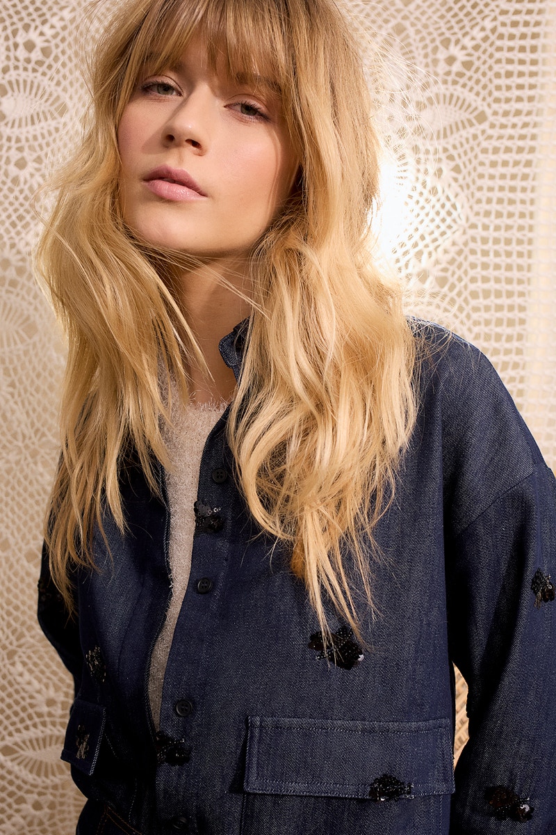 Blaue Damenjacke in Denim-Optik mit dezenten Pailletten-Applikationen, kombiniert mit weißem Top; hochwertige Oui Damenmode.