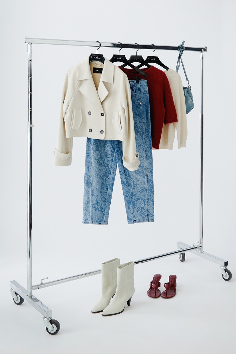 Clothes on a rail, a white jacket at the front, paisley jeans behind it, then a raspberry-coloured knitted jumper.