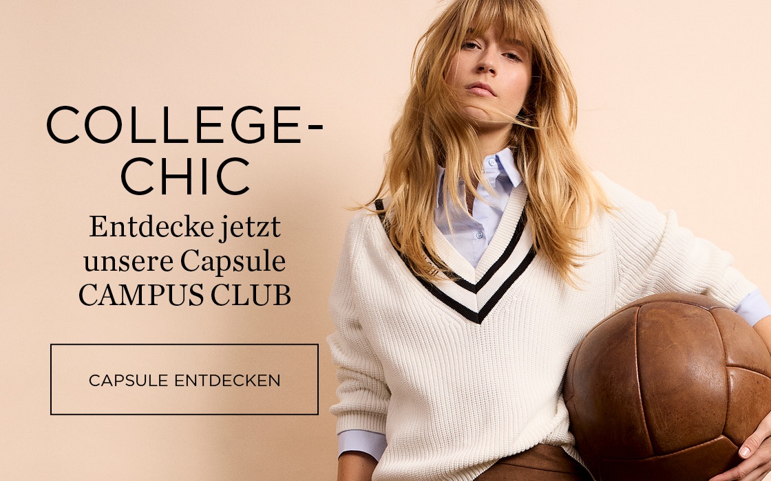 Frau mit einem beigen Pullover mit braunem V-Ausschnitt und einem braunen Rock.