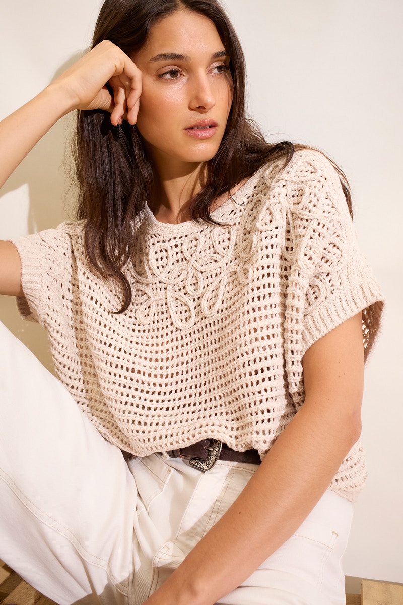 Beiger kurzarm Pullover in Häkeloptik mit weißer Hose.