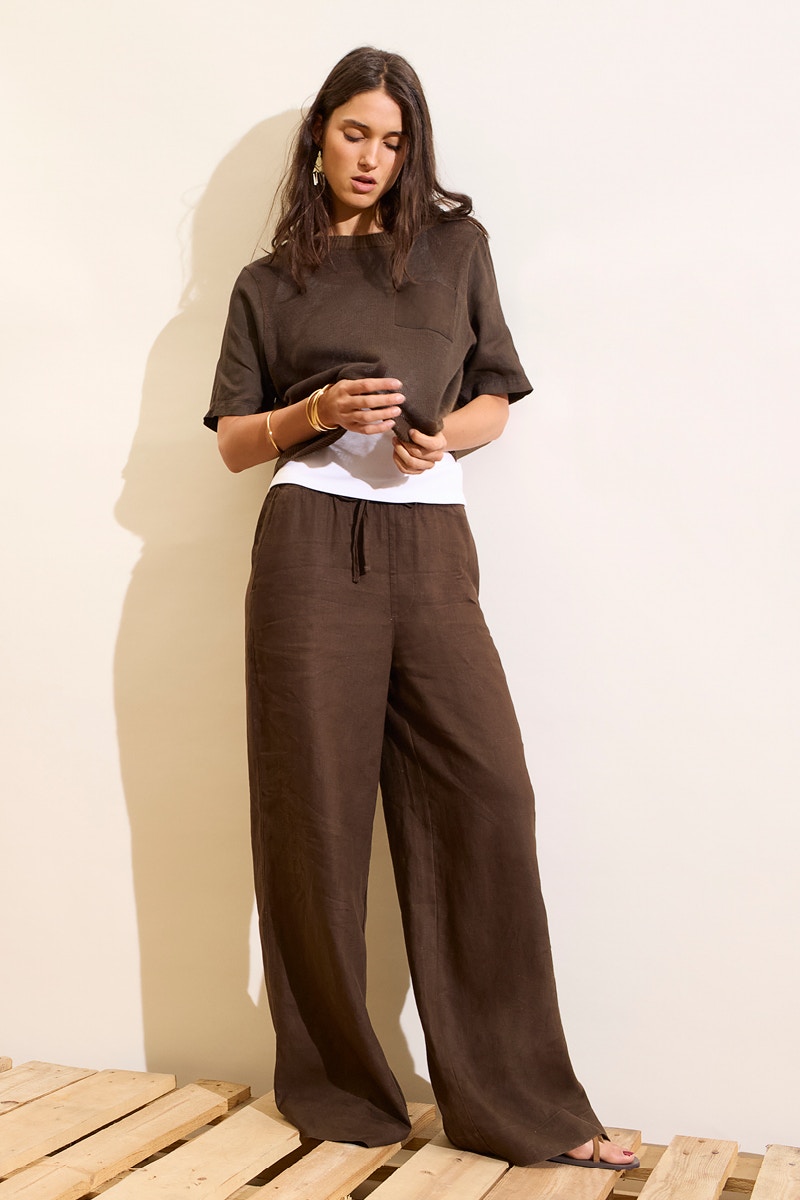 Woman wearing a brown shirt and brown trousers.