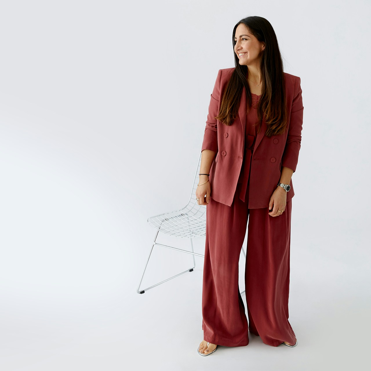 Victoria trägt einen komplett Look in Himbeere. Blazer mit passendem Top und weiter Hose.