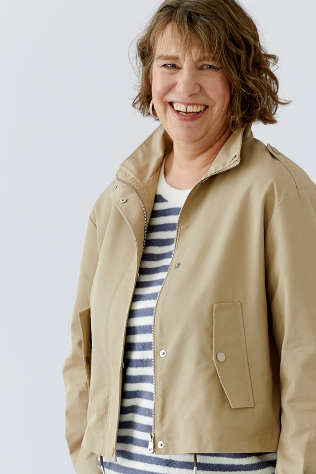 Close-up of Kerstin wearing a beige jacket and a blue and white striped jumper.