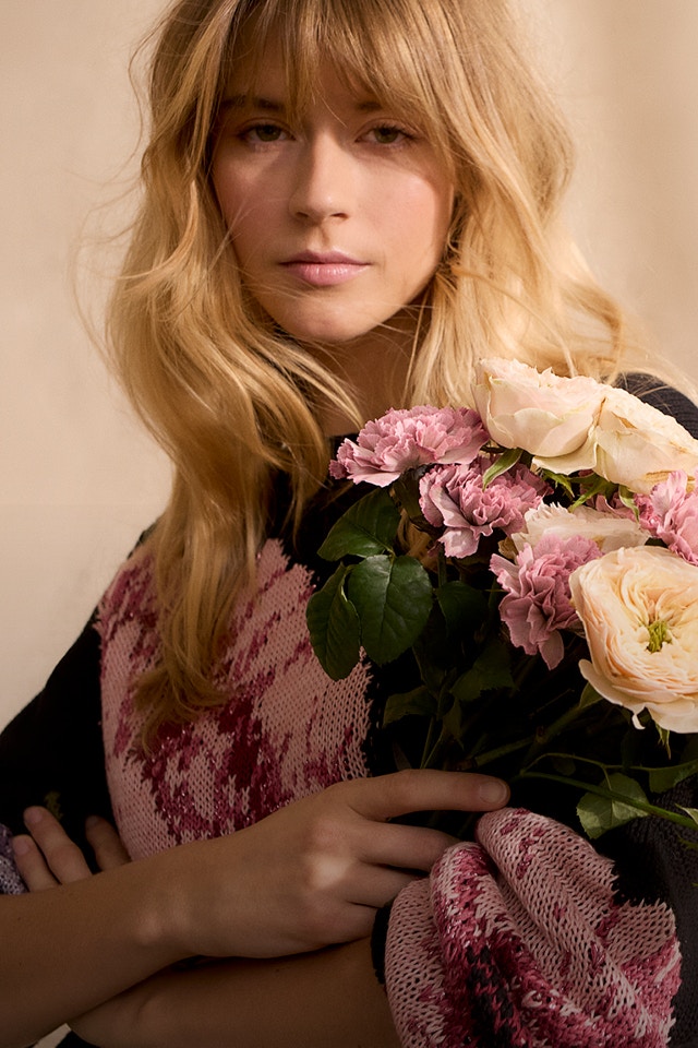 Woman wearing a black jumper with a colourful floral print.