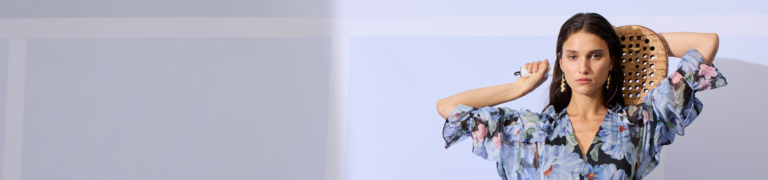 Frau mit geblümtem Kleid mit Rüschendetails in blauer farbigkeit.