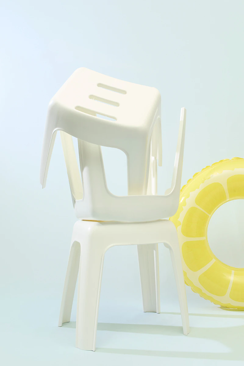 The picture shows three white chairs draped with fabric and a lemon-shaped rubber ring in the background.