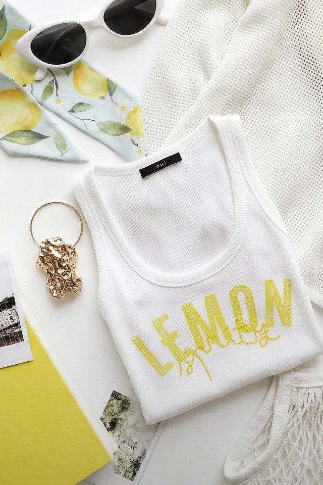 Pleated top in white with a yellow lemon print.