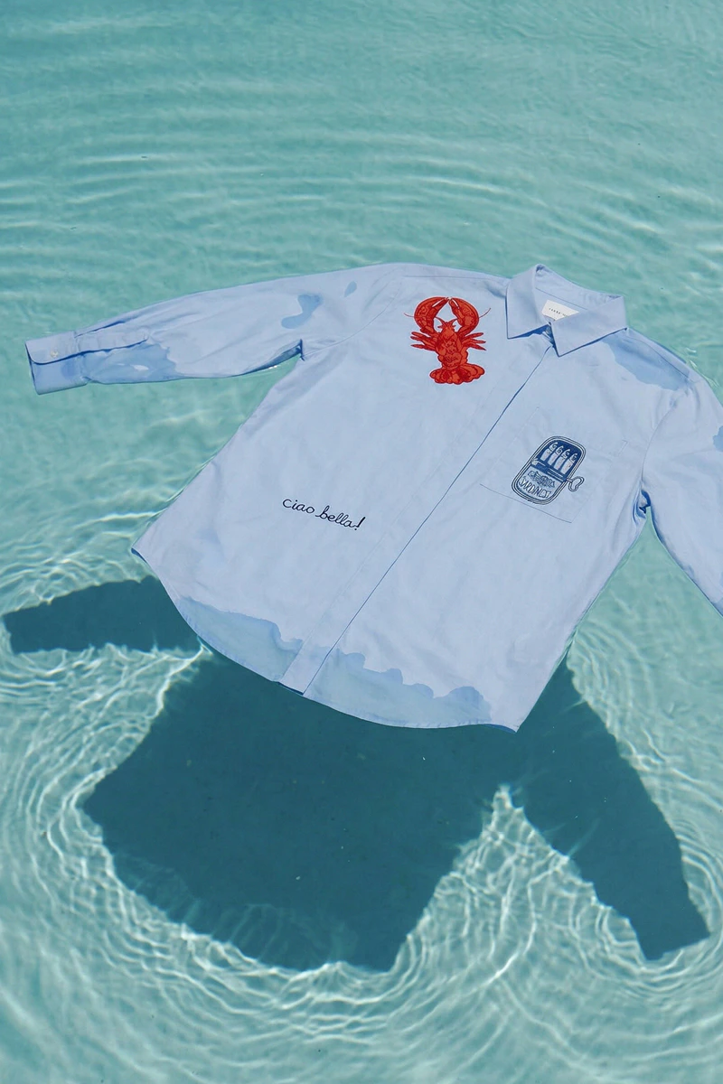 A blue and white striped blouse with red and blue embroidery is floating in a swimming pool.