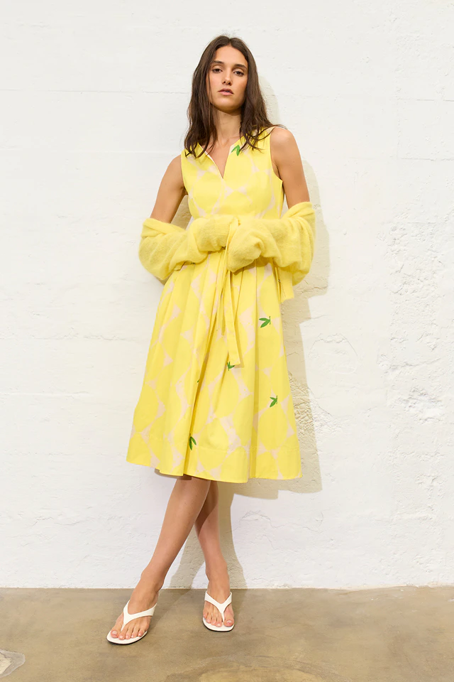 Model trägt Zitronenmuster Blusenkleid in gelb mit gelber Strickjacke