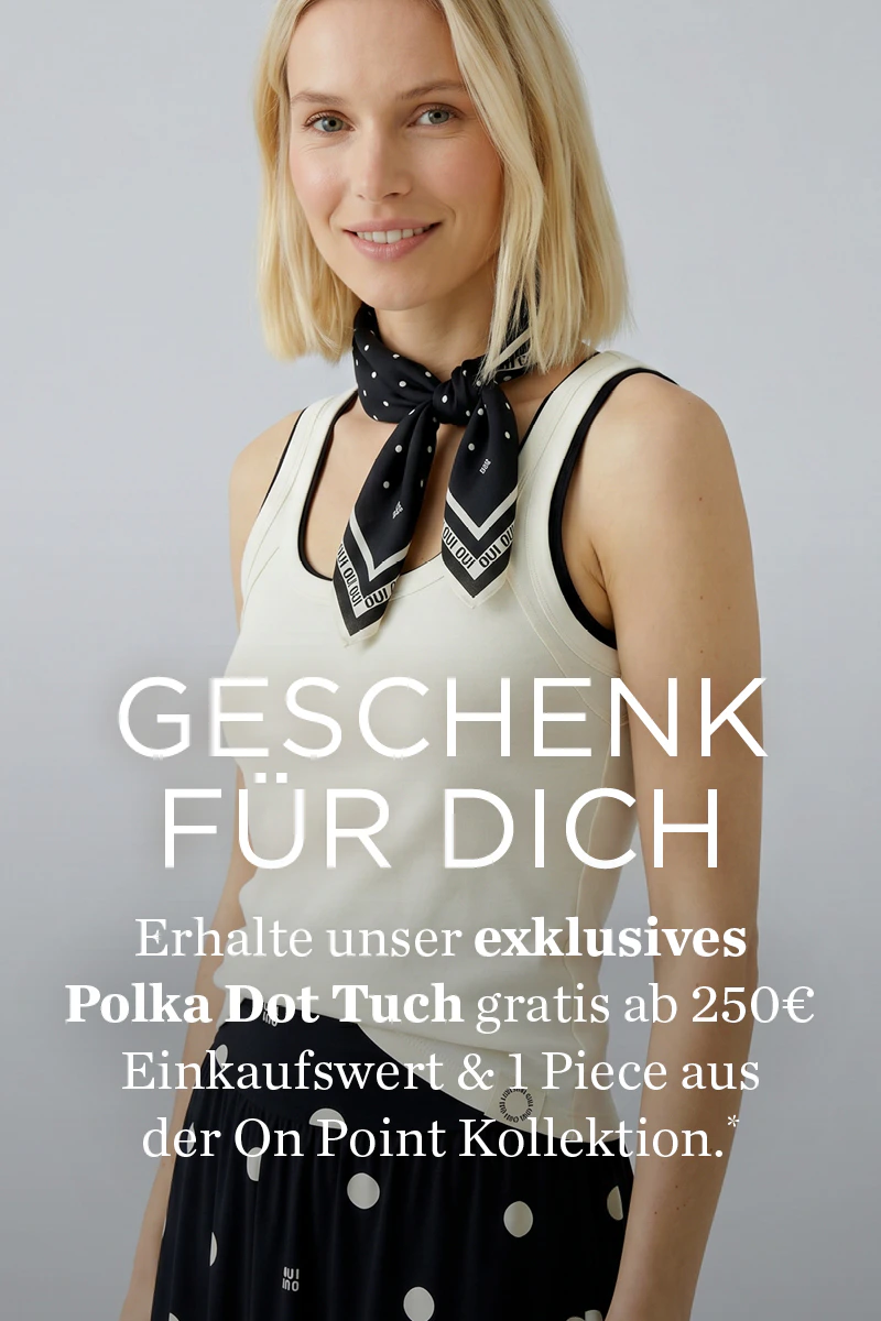 Frau mit weißem Top und schwarz-weissem Schal. Geschenk für Dich: erhalte unser exklusives Polka Dot Tuch gratis ab 250€ Einkaufswert & 1 Piece aus der On Point Kollektion.